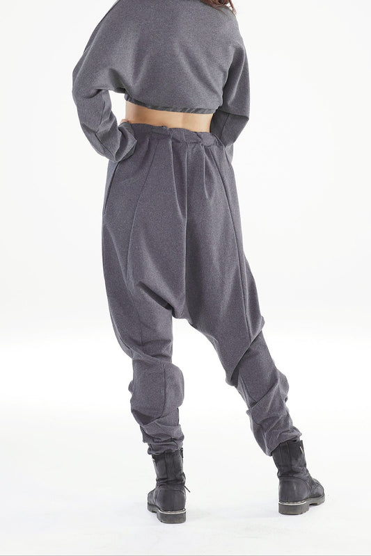 Person wearing a gray outfit with wide-leg pants on a white background