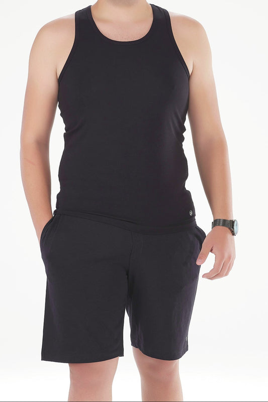 Man wearing a black tank top and shorts on a white background