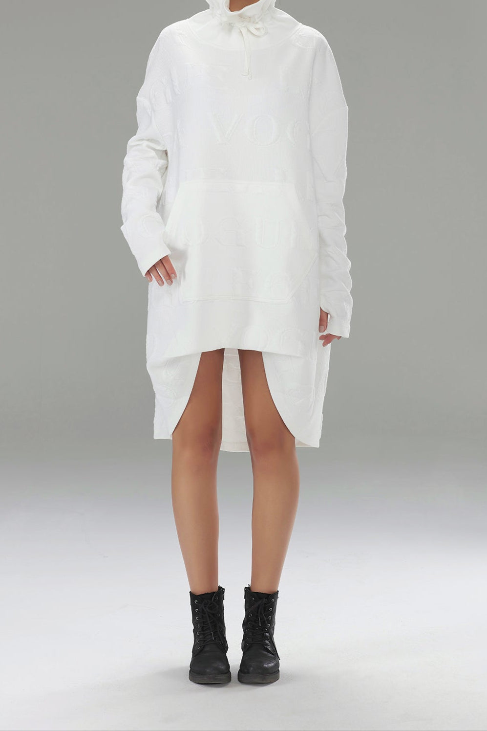 Woman wearing a white high-neck dress with a gray background