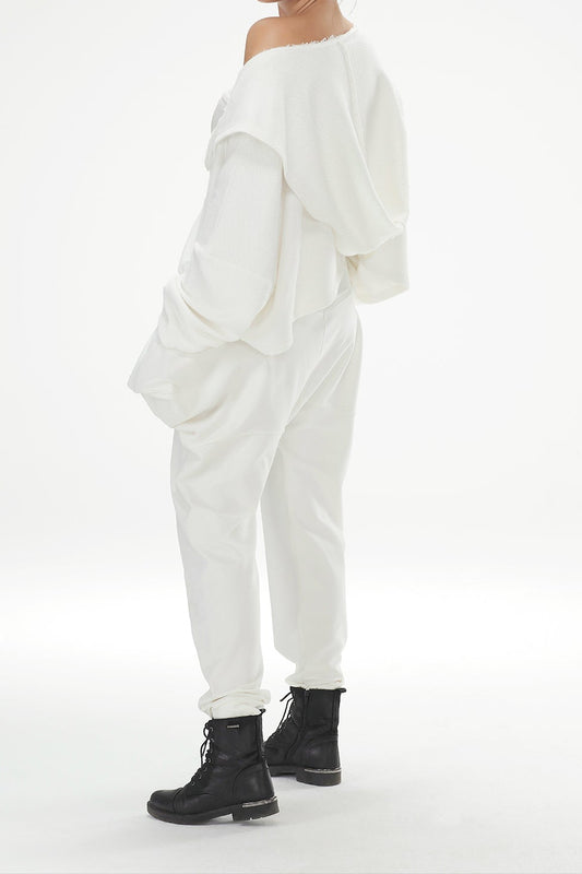 Person wearing a white outfit with black boots on a white background