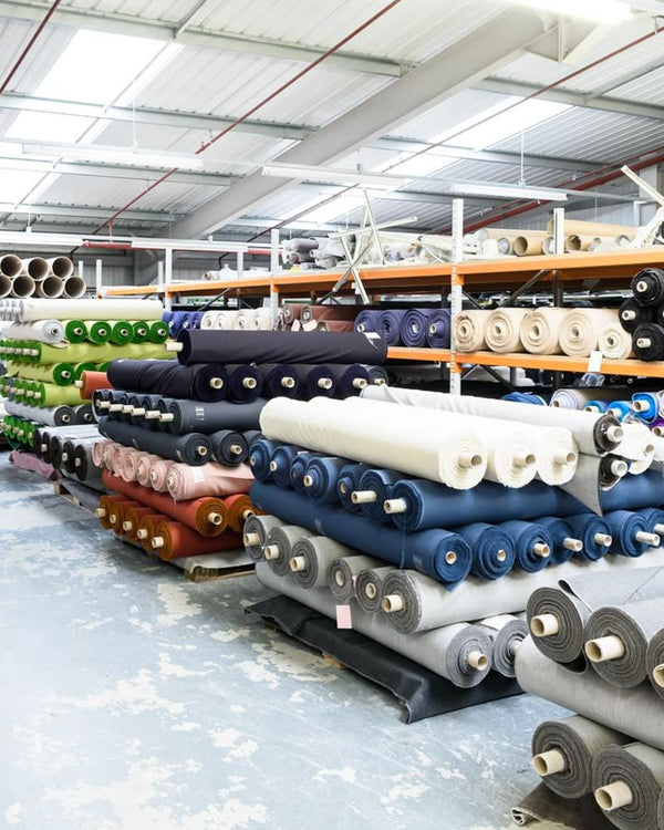 Rolls of fabric stacked on shelves in a warehouse setting